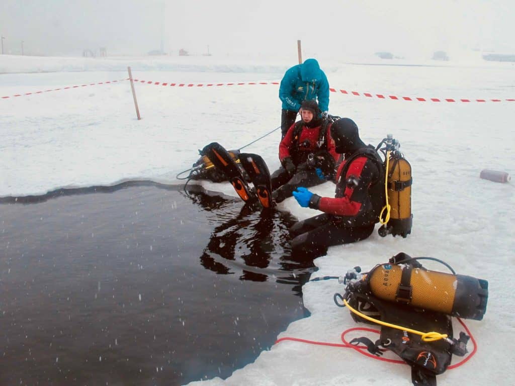 Deux plongeurs sous glace à Tignes se préparent à se mettre à l'eau