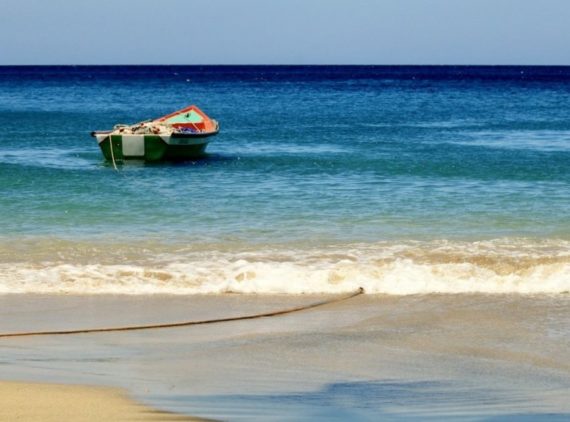 Plonger en Martinique permet de voir de beaux paysages comme cette plage avec le bateau de pêcheur amarré.