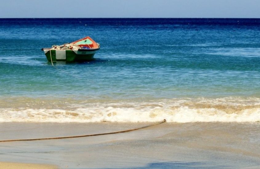 Plonger en Martinique permet de voir de beaux paysages comme cette plage avec le bateau de pêcheur amarré.