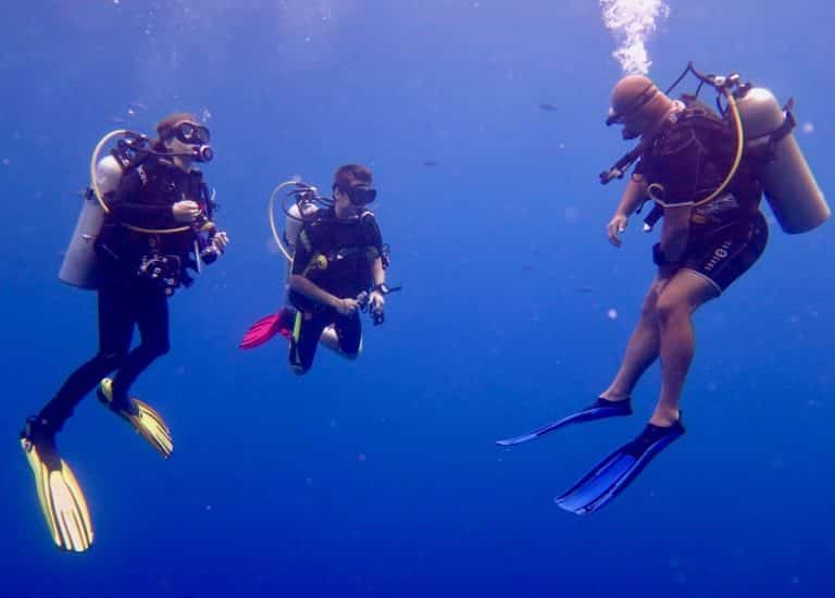Deux plongeurs occupés à passer un premier niveau de plongée avec leur moniteur en Egypte.