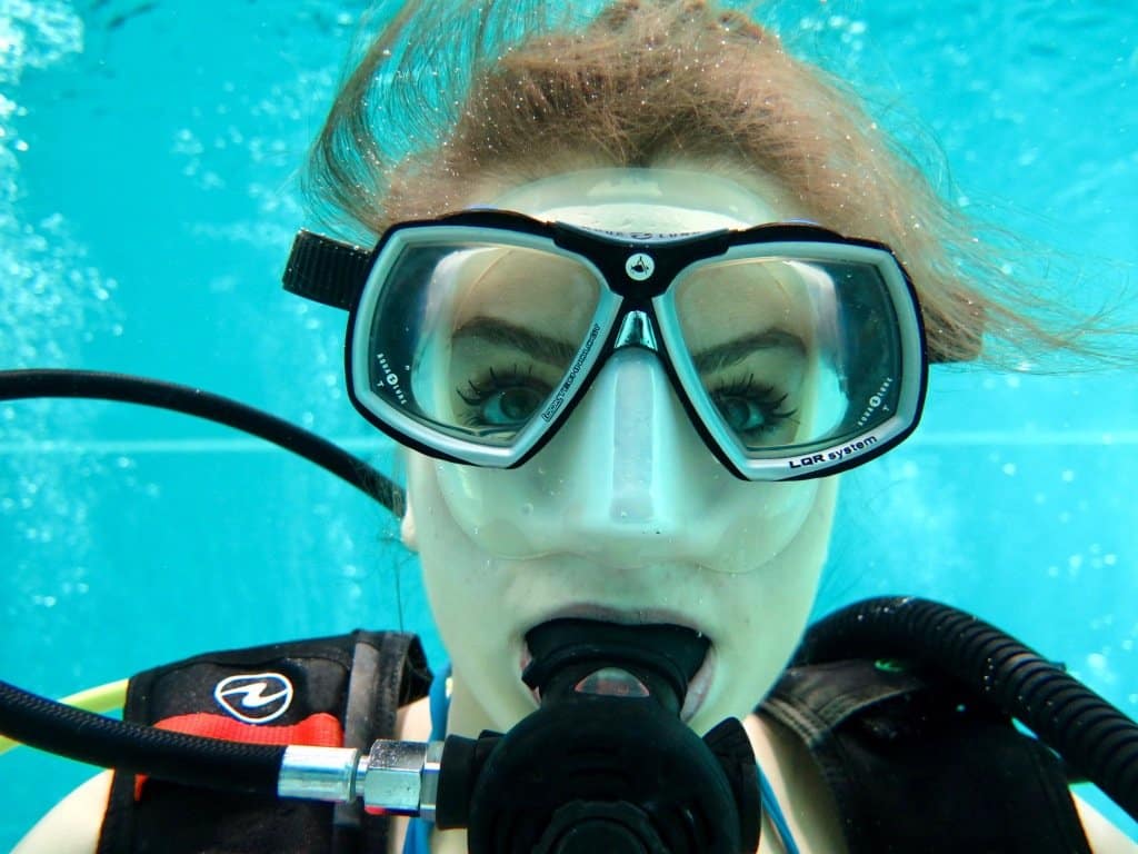 Une femme regarde à travers son masque de plongée