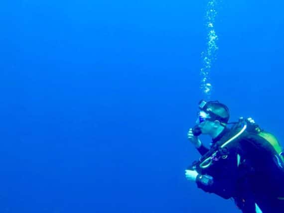 Un plongeur avec sa caméra dans l'océan