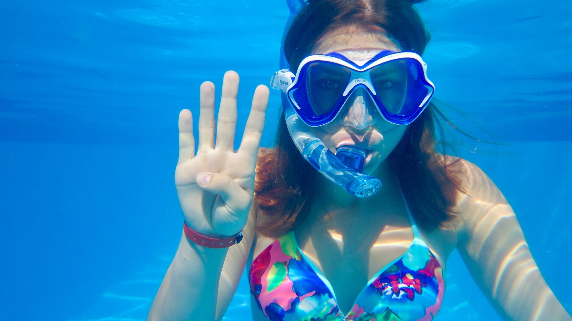 Une jeune plongeuse montre un quatre avec ses doigts