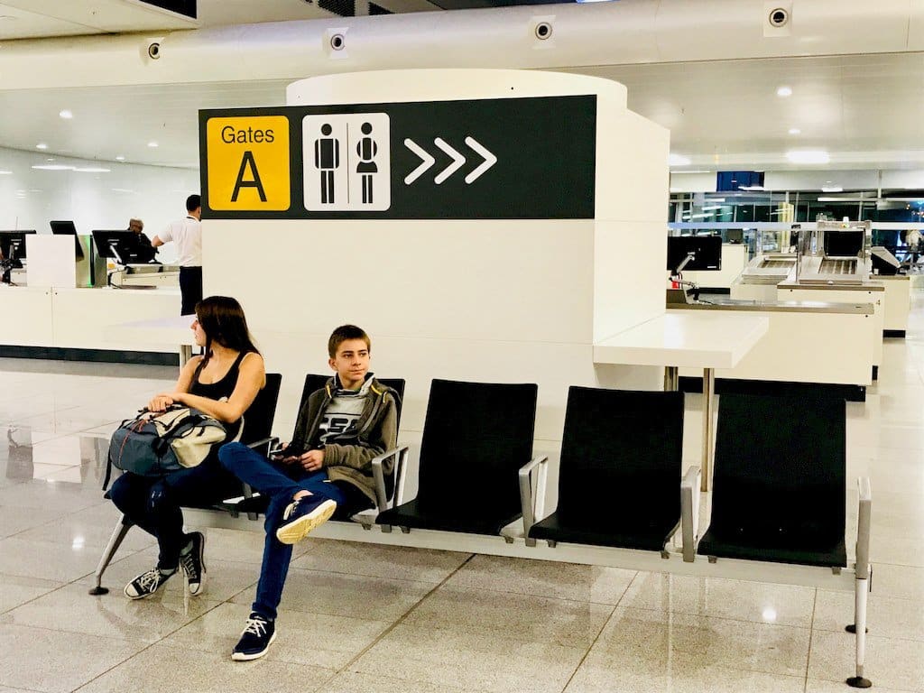 Deux enfants attendent dans le hall d'un aéroport