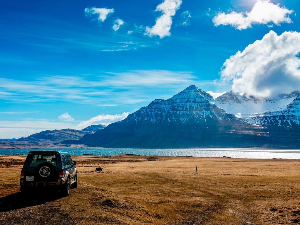 Un paysage d'Islande avec une voiture devant une montagne