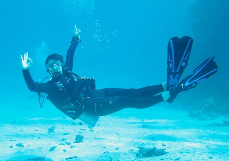 Une plongeuse fait le signe OK sous l'eau