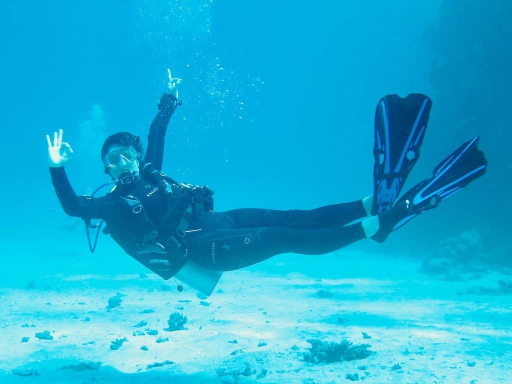 Une plongeuse fait le signe OK sous l'eau