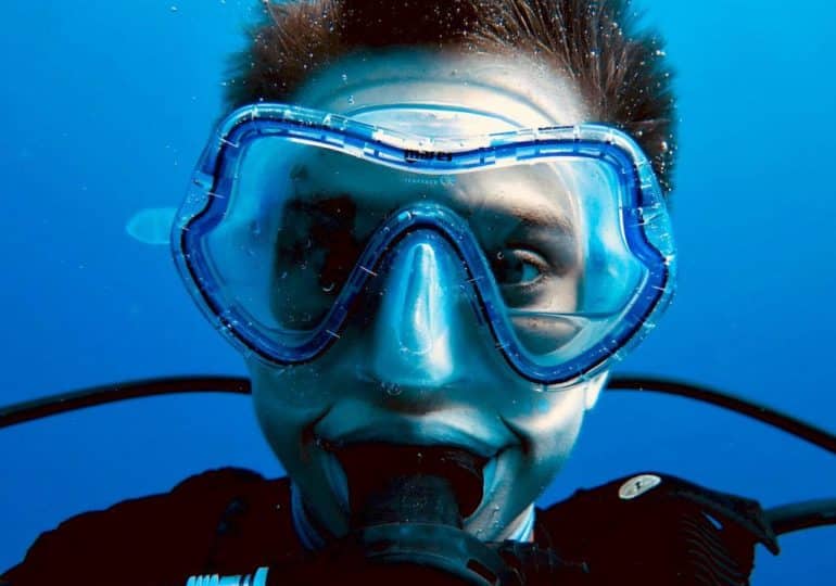 Les citations sur la plongée sous-marine peuvent avoir des effets secondaires de la plongée comme faire sourire ce plongeur au regard bizarre qui fixe l'objectif.