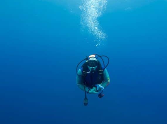 Un plongeur seul dans le grand bleu tente d'acquérir de l'expérience en plongée.