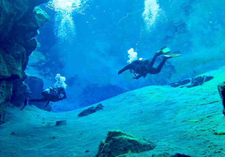 Deux plongeurs à la sortie de la grande crevasses de la faille de Silfra