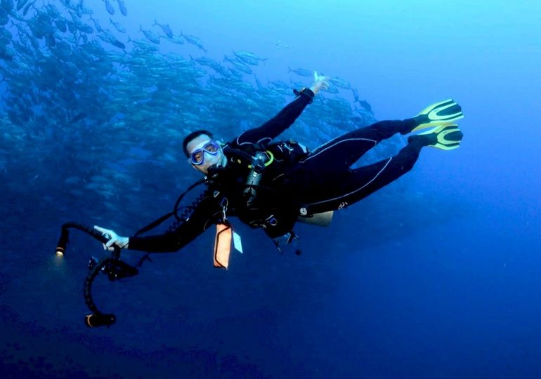 Un plongeur sous l'eau avec son appareil photo pour capturer la beauté de la plongée