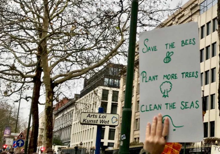 Une main portant une affiche en faveur des action pour le climat