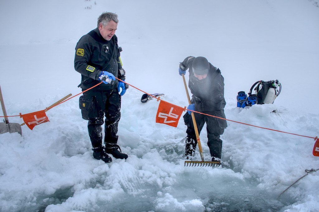 Deux plongeurs travaillent pour dégager la glace