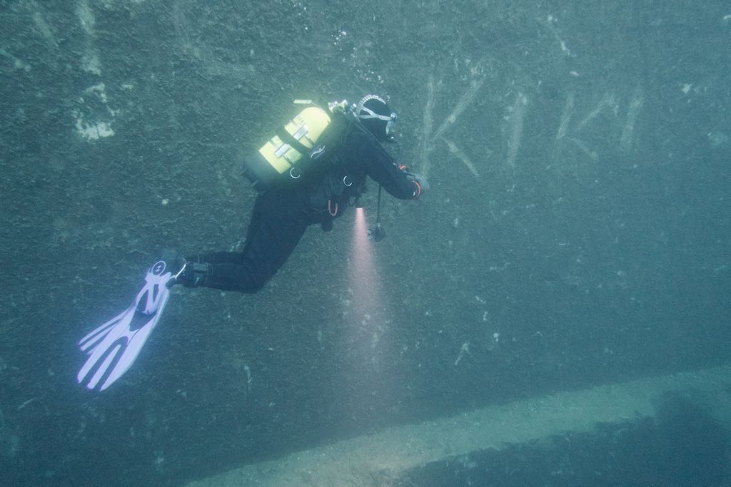 Un plongeur passe près d'une inscription dans l'eau