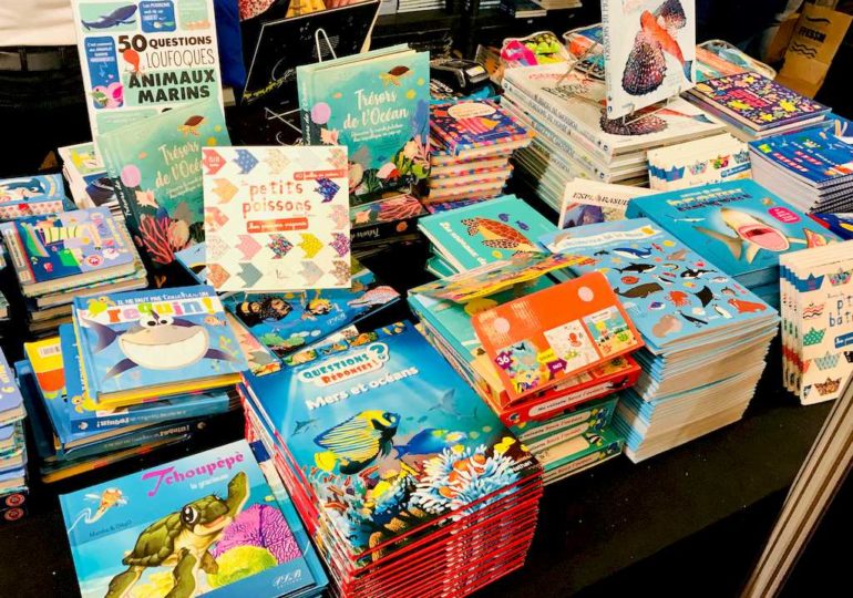 Des livres sur les océans pour les enfants exposés sur un stand au Salon de la Plongée de Paris