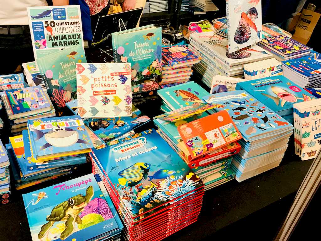 Des livres sur les océans pour les enfants exposés sur un stand au Salon de la Plongée de Paris