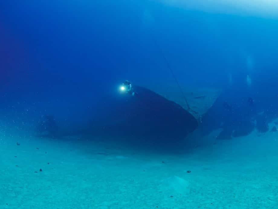 ilma Hooker à Bonaire vu de devant à -30 m de fond avec trois plongeurs