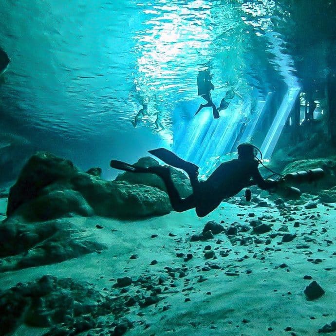 Des plongeurs dans la cénote de Dos Ojos au Mexique.