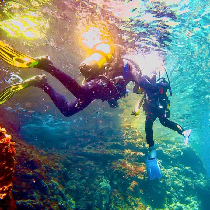Deux plongeurs dans les eaux d'Espagnes fondent dans les nuances de bleu.