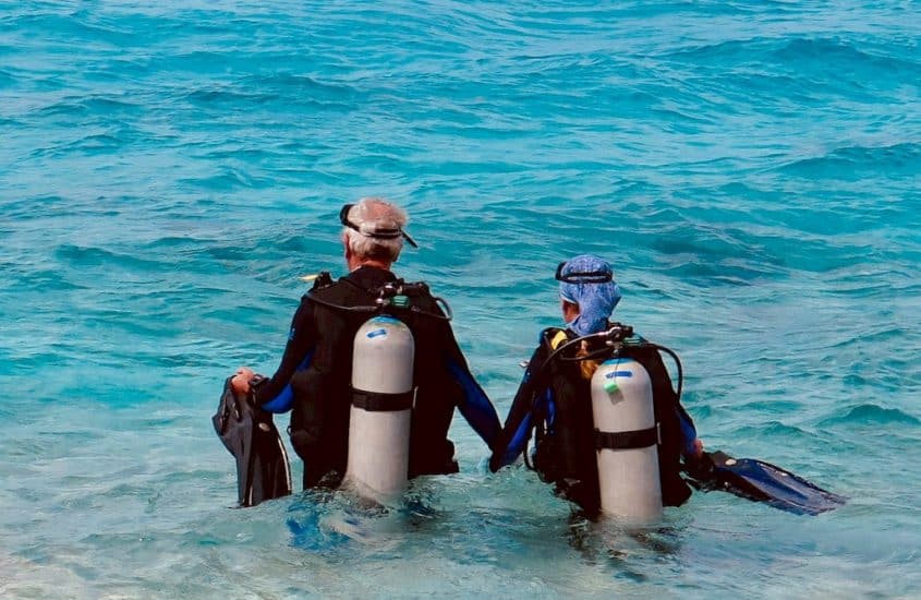 Plongée et ménopause demande parfois du soutien comme pour cette dame aidée par son mari à entrer dans l'eau à Bonaire.
