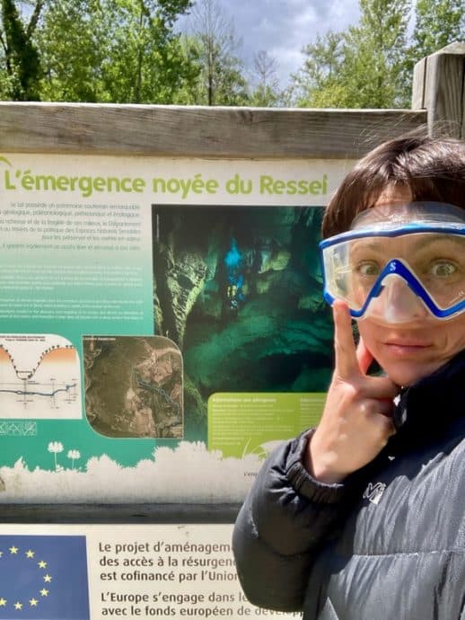 Hélène Adam devant le panneau du site de plongée souterraine du Ressel.