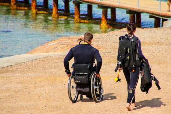 Plongée et handicap sont loin d'être incompatibles, comme pour ce monsieur en chaise roulante qui se rend à la mise à l'eau.