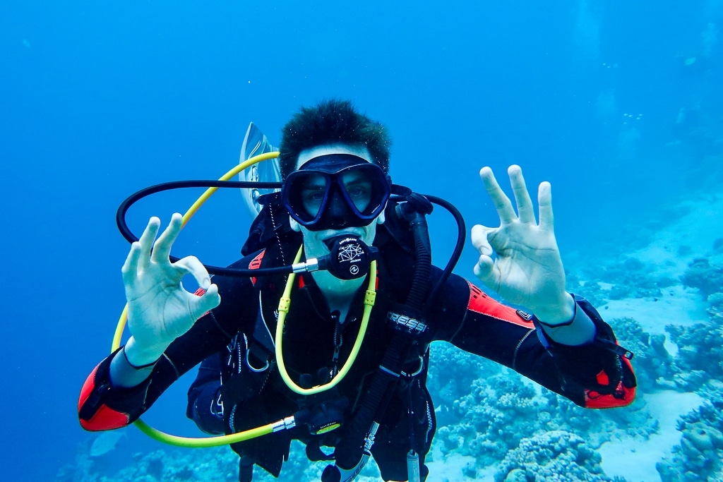 Un plongeur fait le signe OK sous l'eau.