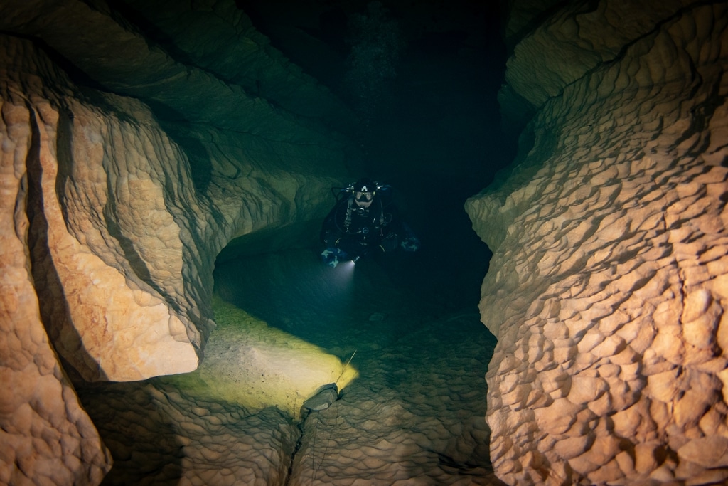 un plongeur évolue dans une galerie souterraine dans le Lot.