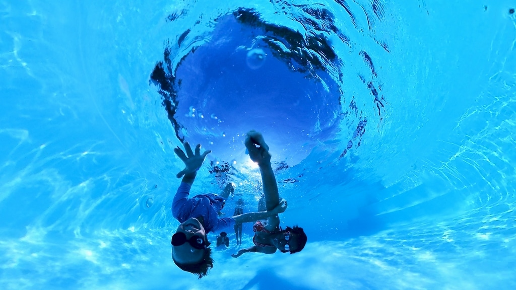 Un enfant joue dans la piscine avec la caméra Insta360 X3.