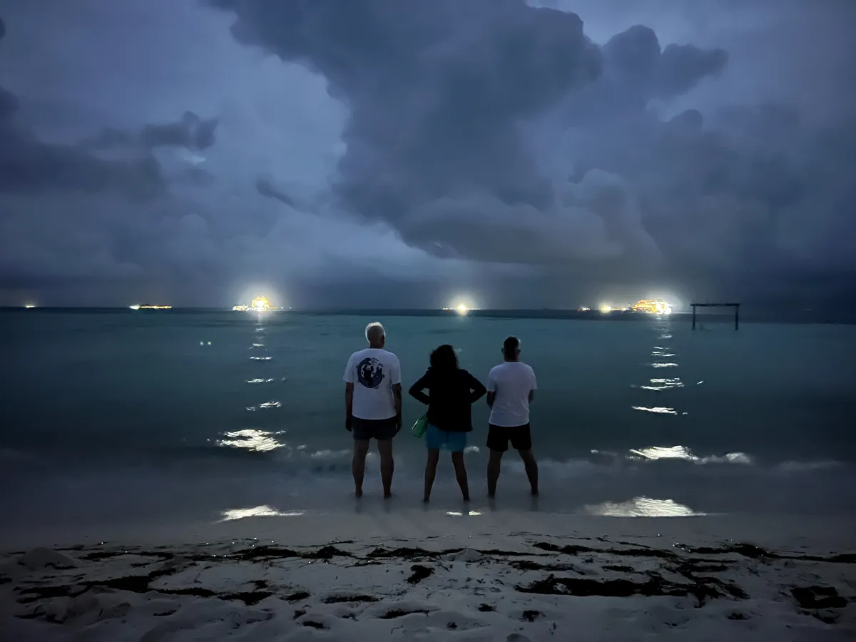 Trois plongeurs au bord de l'eau